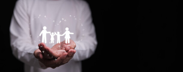 Hands holding family icon with hearts on dark background. Families love, mental health, emotional support, insurance protection, budgeting awareness, foster care, homeschool, and wellbeing