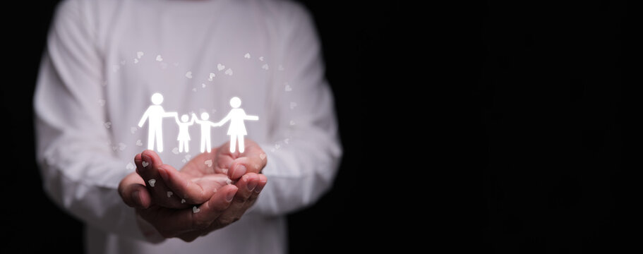 Hands holding family icon with hearts on dark background. Families love, mental health, emotional support, insurance protection, budgeting awareness, foster care, homeschool, and wellbeing