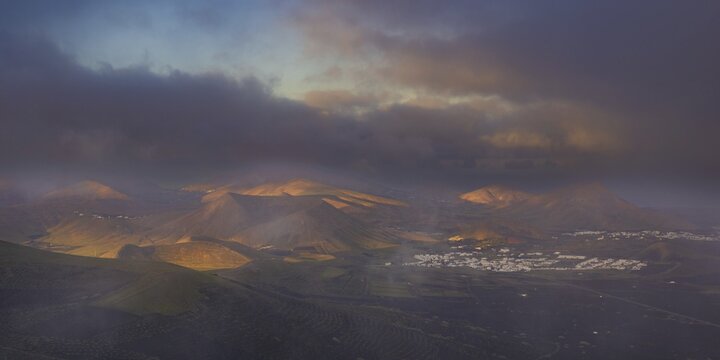 Panorama at sunrise from Montana de Guardilama to the wine-growing region of La Geria, with the villages of Uga and Yaiza behind, Lanzarote, Canary Islands, Spain