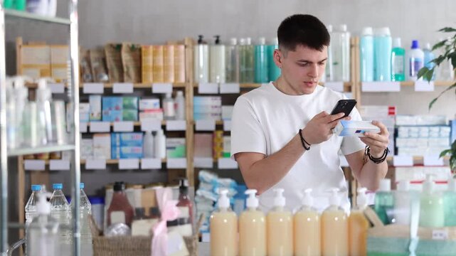 European guy in a pharmacy with a sore throat and cough. Young man came to the pharmacy for medicines for colds and flu. Buyer in search of sore throat pills in a pharmacy. High quality 4k footage