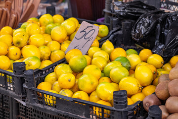 Colorful Display Of Lemons at fruit and vegetables street Market, organic ecological food from local producers. Ripe Yellow Lemons Close-up Background Or Texture. Lemon Harvest, Many Yellow Lemons.