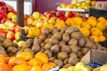 Display of ripe kiwis at the farmers' market. Many kiwis are sold at the store. Vegetarian and healthy food. Farmers' market with fresh fruits and vegetables.