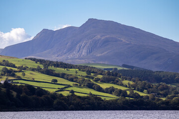 Calm daylight view across Bala Lake with distant hills and drifting clouds