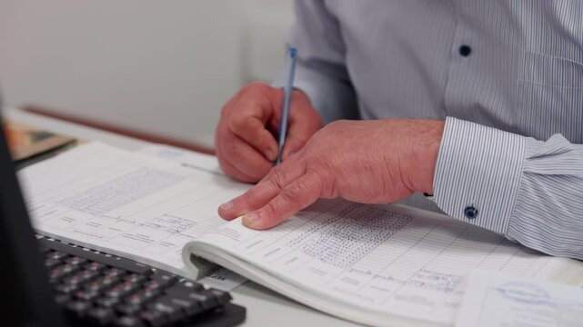 Professional man engaged in meticulous documentation, writing in a ledger with a pen, showcasing attention to detail, camera zooms in on the action