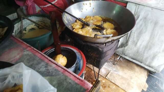Deep Frying Delicious Golden Fritters in Hot Oil at a Street Food Stall