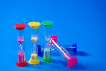 Hourglasses on blue background with copy space