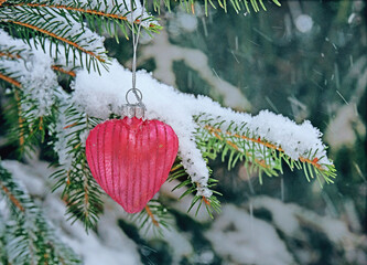 A toy heart on a Christmas tree in the park