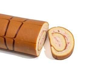 Swiss roll with strawberry cream and one sliced piece beside it, isolated on white. Sponge cake spiral with chocolate stripes, baked dessert concept.