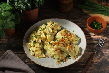 Traditional Swabian dish Maultaschen served with roasted onion and potato salad