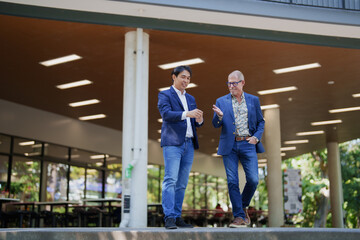 Businessmen walking and talking during casual outdoor meeting