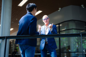 Business colleagues making thumbs up gesture during outdoor meeting