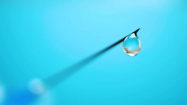 Macro shot of medical syringe with fluid drop suspended at tip. Precision tool for injections and treatments. Concept of vaccination, clinical procedures, pharmaceutical applications