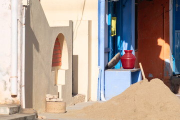 Colorful village street in rural Tamil Nadu with traditional architecture, clay pot, and...