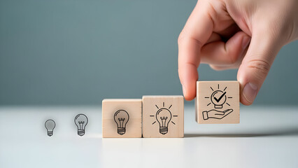 Hand placing wooden block with lightbulb drawing on row of idea blocks