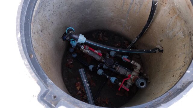 Close-up view of plumbing components inside a maintenance access point, showcasing intricate details and textures, camera gradually zooms in for enhanced focus
