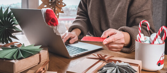 Online Christmas shopping with credit card and laptop, gift boxes and candy cane mug on desk — holiday sale and discounts, e-commerce banner with copy space for promo, Cyber Monday and Black Friday