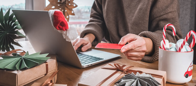 Online Christmas shopping with credit card and laptop, gift boxes and candy cane mug on desk — holiday sale and discounts, e-commerce banner with copy space for promo, Cyber Monday and Black Friday