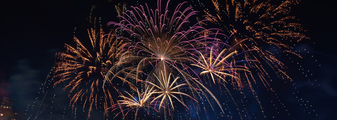 Colorful fireworks explode over the city skyline at night, celebrating the arrival of 2026 with...