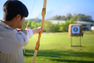 Archer aiming at target in open field