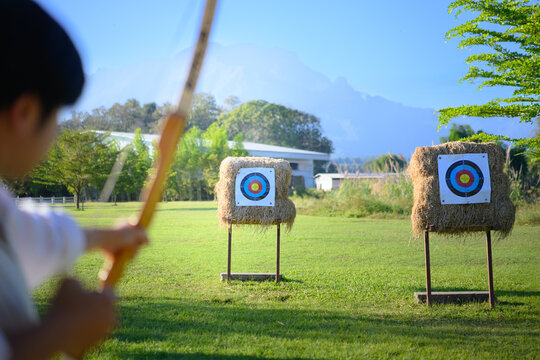 Archer aiming at target in open field