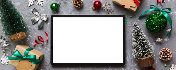 Top view of empty tablet on Christmas background made of new year decorand festive decorations. New year holiday concept. Mockup