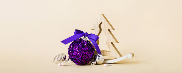 Christmas ball with decorative wooden tree on colored background. decoration bauble with ribbon bow with copy space