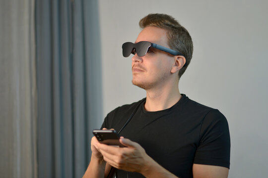 Man Using Futuristic AR Glasses with Smartphone Controller