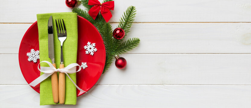 Christmas table place setting with christmas decor and plates, kine, fork and spoon. Christmas holiday background. Top view with copy space
