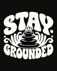Stay Grounded is seen above stacked stones and a lotus flower on black background