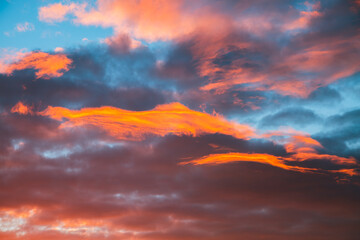 Incredible sunset over horizon creates a breathtaking canvas of vibrant orange and pink clouds in the evening sky.