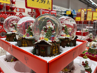 Festive christmas snow globes with santa claus displayed in holiday store setting