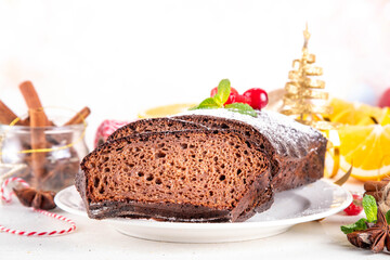Homemade gingerbread loaf cake. Freshly baked Christmas Gingerbread chocolate cake with sugar powder topping, on white festive decorated background