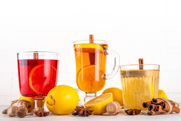 Three different Hot Toddy drinks in different tea cups - hot autumn winter tea cocktail beverages with scotch, rum and mezcal alcohol drinks, spices, lemon and honey