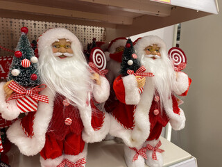 Festive santa claus figurines holding candy and christmas tree decor for holiday displays