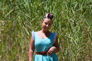 A beautiful young Spanish woman dressed in a traditional green flamenco dress and a flower in her...