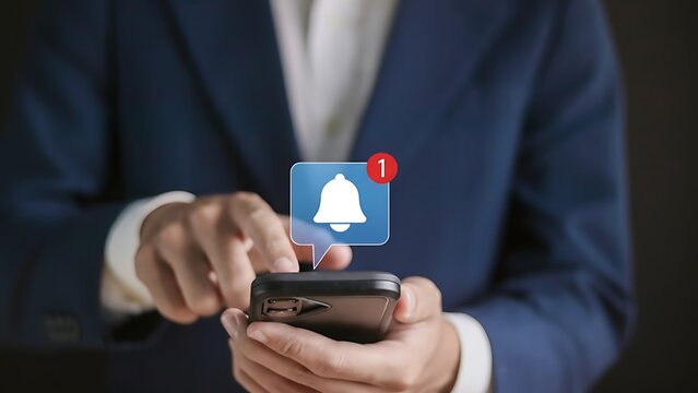 Businessman checking smartphone for notifications, bell icon with a red alert