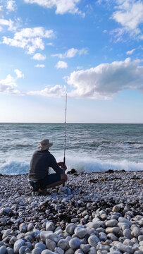 Man Fishing on Rocky Coast of &Eacute;tretat, France