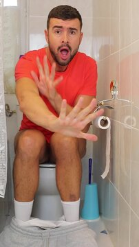 Embarrassed looking man caught by someone in the toilet 