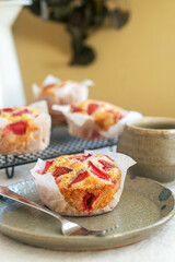 Homemade strawberry white chocolate muffins on handmade clay plate.
