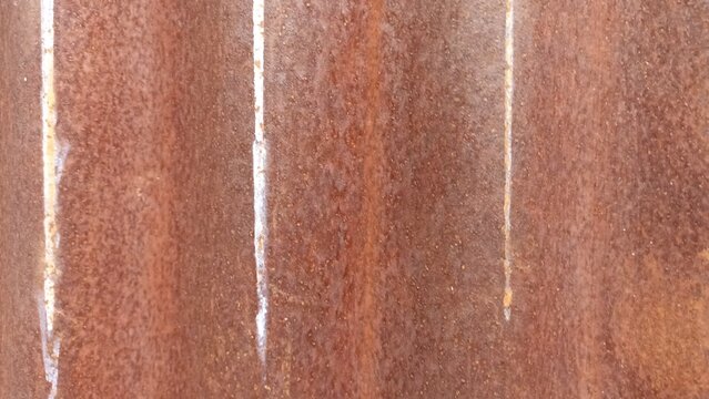 Rusty Corrugated Metal Roof With White Streaks. A heavily rusted corrugated metal surface with deep orange corrosion and distinct vertical white runoff streaks - Powered by Adobe