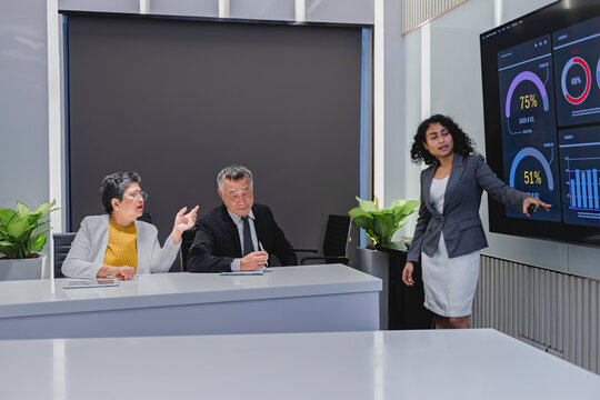 Diverse business team analyzing financial data and performance metrics during a corporate meeting. Professional teamwork, strategy planning, and data-driven decision making in modern office.