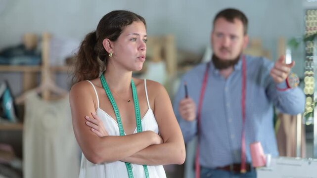 Upset seamstress scolded by colleague in workshop. High quality 4k footage