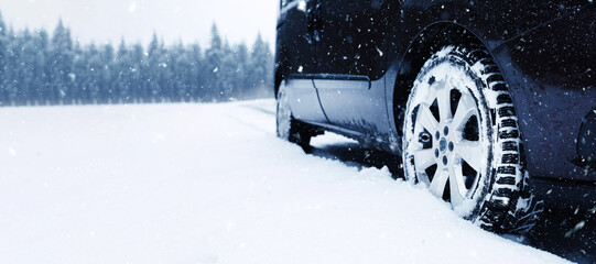 Naklejka premium Car on snowy country road, closeup. Adverse weather conditions
