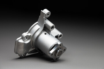 High-quality spare parts for your car. Car maintenance. New water pump for the engine cooling system on a gray gradient background.
