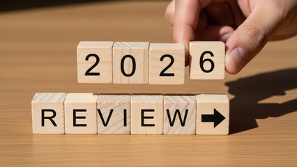 Hand placing 2026 review blocks for future business assessment