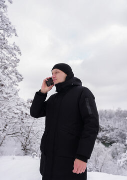 Man talking on the phone outside in snowy winter landscape