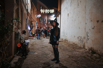 Little girl and mother trick-or-treating on Halloween night