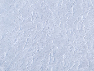 Frozen lake covered in snow, patterns and textures of drifting snow creating shadows on a lake