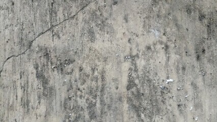 Cracked Grey Concrete Wall Texture. An old grey concrete wall surface showing a prominent diagonal crack, dark dirt stains, and rough weathered texture