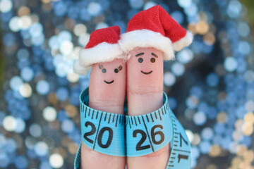 Fingers art of couple celebrates Christmas. Concept of man and woman laughing in New Year hats. Measuring tape is written 2026